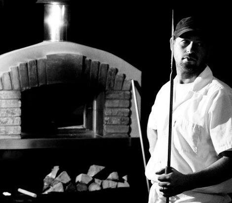 Jay Clement, owner of Pizzeria Moto, Virginia standing in front of pizza oven